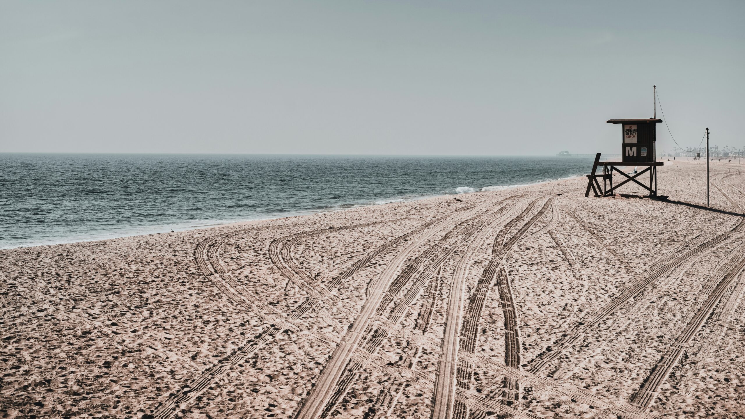 shoreline of long beach california sand with tire tracks and ocean